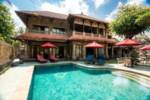 a house with a swimming pool in front of a house at Bali Villa Djodji in Ubud