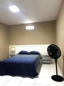 una camera con letto blu e ventilatore di Casa no Forte Orange a Vila Velha