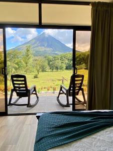 Habitación con 2 sillas y vistas a la montaña en Paraíso privado Arenal Dragonfly, en Fortuna