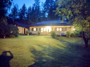 a house with lights on in a yard at night at Villa Lovisa in Loviisa