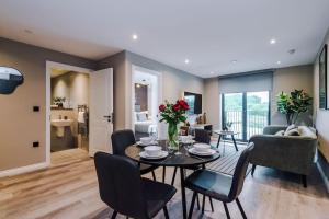 a dining room and living room with a table and chairs at 2 Bedroom Apartment Leeds City Centre - Free Parking in Leeds