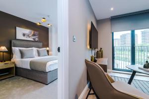 a bedroom with a bed and a desk and a window at 2 Bedroom Apartment Leeds City Centre - Free Parking in Leeds