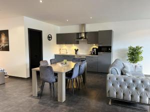 a kitchen and dining room with a table and a couch at Loft à la Source in Francorchamps +18 photos