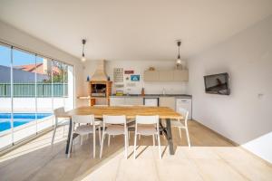 una cucina e una sala da pranzo con tavolo e sedie in legno di GuestReady - Sunshine oasis with pool ad Azeitao