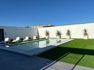 a swimming pool with chairs in a yard at Apartamentos Al Paso de Toledo, Puy du Fou a 10km in Burguillos de Toledo