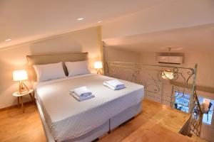 a bedroom with a bed with two towels on it at Thea Suite & Loft in Kavala