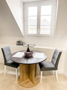 einen Tisch mit zwei Stühlen und eine Flasche Wein darauf in der Unterkunft Appartement 2 moderne - centre in Alençon + 16 Fotos