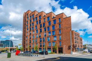 a large brick building on a city street at Stylish Leeds City Centre Flat - Free Parking in Leeds