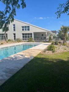 una casa con piscina di fronte a una casa di La Villa Blanche - 18 personnes a Pénestin