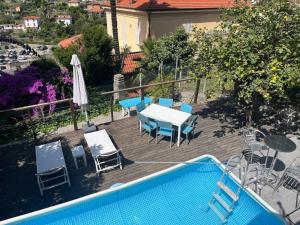 a patio with a table and chairs and a pool at Villetta Fioregreco - free parking - Large outdoor space in Sanremo