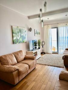 a living room with a couch and a television at Romantic Hillside Escape Sea View in Budva