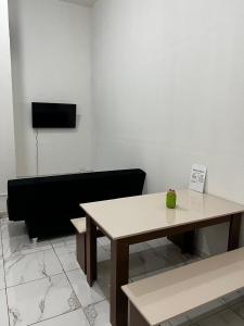 a room with a table and a black couch at Casa Ana Brutomesso 1 in Londrina