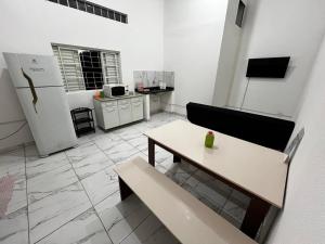 a living room with a table and a refrigerator at Casa Ana Brutomesso 1 in Londrina