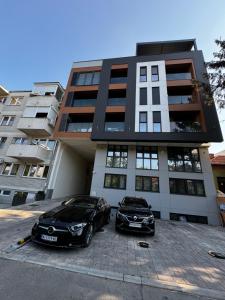 two cars parked in front of a building at MAR Residence 15 in Niš