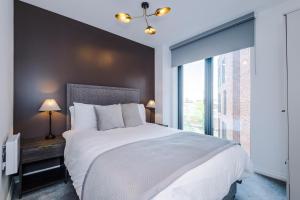 a bedroom with a large bed and a large window at Premium 3 Bed Apartment City Centre - Free Parking in Leeds