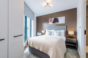 a bedroom with a large bed and a window at Premium 3 Bed Apartment City Centre - Free Parking in Leeds