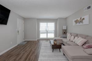 a living room with a couch and a tv at Classic Charm by the Park in Columbus
