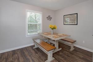 a dining room with a wooden table and benches at Classic Charm by the Park in Columbus