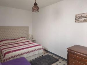 a small bedroom with a bed and a dresser at Riad Agadir avec terrasse toit in Agadir