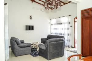 Una sala de estar con dos sillas y un televisor. en Stay At RichmondHill, en Galle