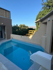 a swimming pool with blue water in front of a house at Classic apartment Meronas in Méronas