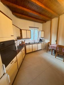a large kitchen with white cabinets and a table at Classic apartment Meronas in Méronas