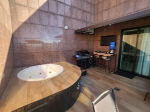 a large bathroom with a tub and a table at Savassi Tower Cobertura in Belo Horizonte