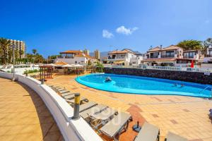 a large swimming pool with chairs and people in it at Apartment Paraiso Royal in Arona