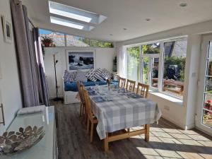a dining room with a table and chairs and a couch at Langurra in Newquay