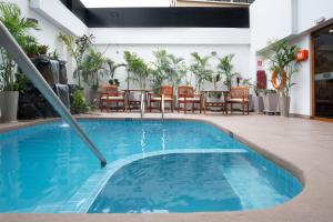 a pool in a hotel with chairs and a table at Crowne Plaza Lima - Miraflores by IHG in Lima