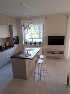 a kitchen with a island with two stools and a table at CZARTORYSKICH 7 - 3 pokoje - Faktura - Parking w cenie !! in Puławy