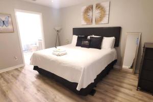 a bedroom with a large bed with white sheets and pillows at Welcome to Tranquility House in Tampa
