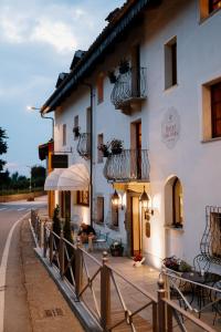 a building with tables and an umbrella on a street at Hotel Casa Pavesi in Grinzane Cavour