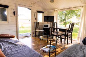 a tiny house with a dining room and a table at Stuga med panoramafönster, paradis för fågelskådare och vandrare, självstäd efter besök in Mörbylånga