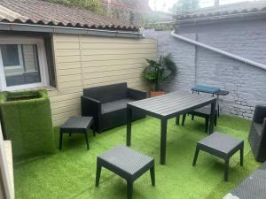 a patio with a table and chairs on the grass at La casa di Vito in Lallaing