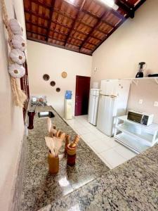 eine Küche mit Granitarbeitsplatte und eine Küche mit Geräten in der Unterkunft Casa de Praia em Maceió AL - 100m da praia in Maceió
