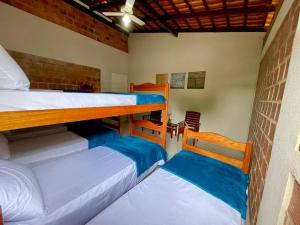 ein Zimmer mit zwei Etagenbetten mit blauer Bettwäsche in der Unterkunft Casa de Praia em Maceió AL - 100m da praia in Maceió + 32 Fotos