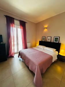 sypialnia z dużym łóżkiem z czerwonymi zasłonami w obiekcie Apartment Antonella w mieście Ostuni