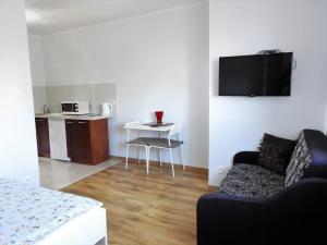 a living room with a couch and a table and a kitchen at Dom Wczasowy Adela in Łeba