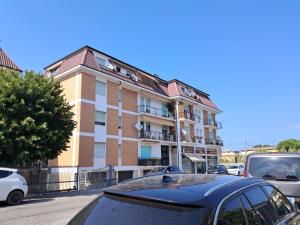 Un edificio con coches aparcados delante. en Roses house, en Porto San Giorgio