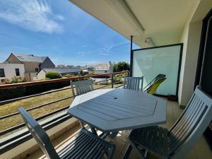 a wooden table and chairs on a balcony at Quiberon : 2 pièces confortables avec Wifi et parking proche plage - FR-1-478-143 in Quiberon