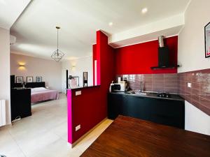 a kitchen with red and black cabinets and a bedroom at Apartment Antonella in Ostuni