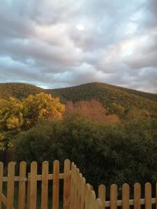 a wooden fence in front of a hill with trees at hebergement chez l'habitant Hyères Campagne in Hyères