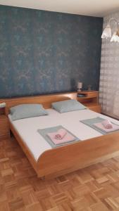 een slaapkamer met een bed met twee roze handdoeken erop bij Villa lavanda in Lovinac