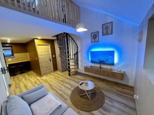a living room with a couch and a tv at Le Loft Cappuccino in Dunkerque