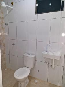 a bathroom with a toilet and a sink at Casa do Pepe em Barra de Jacuípe in Camaçari