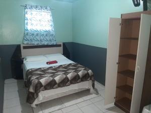 a small bedroom with a bed and a window at Vivendas do Trabalhador in São Francisco do Sul