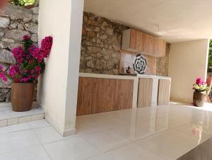 a kitchen with a counter and flowers on the wall at NIKOLARI RESORTs in Himare