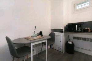 una mesa pequeña y sillas en una habitación con microondas en Studio 30m2 en centre-ville, en Montpellier