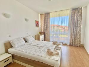 ein Schlafzimmer mit einem Bett und einem großen Fenster in der Unterkunft Apartments in Sunny Island Complex in Tschernomorez + 190 Fotos